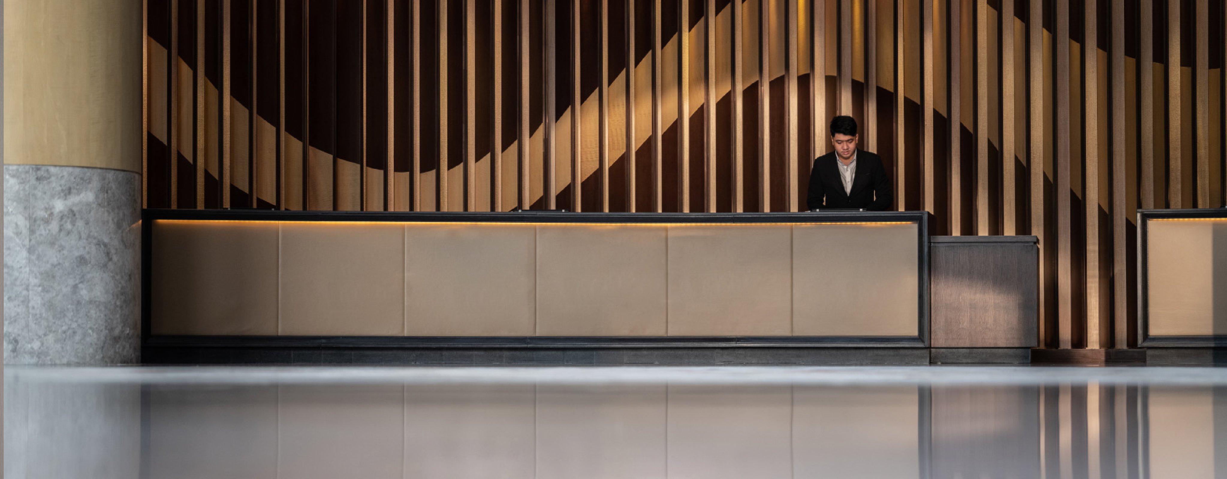 a man working at the front desk checkin area at the New World Saigon Hotel in District 1